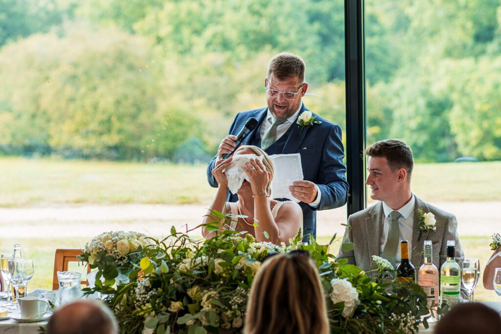 Man giving speech at wedding reception.