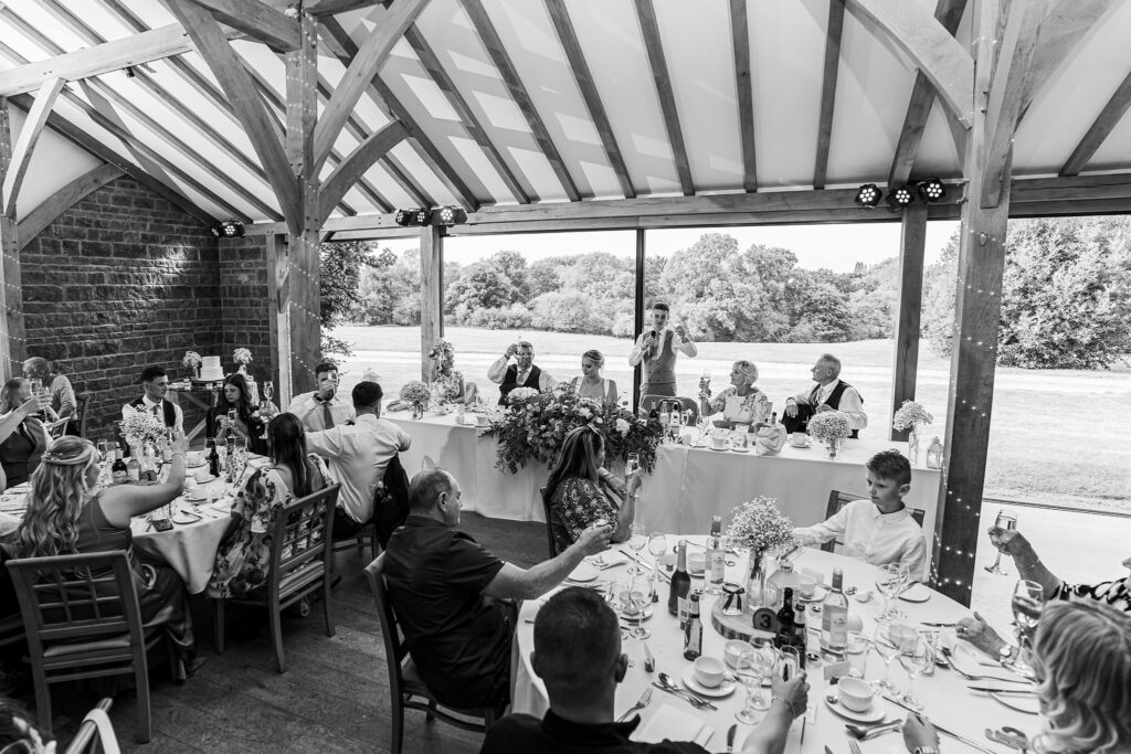 Wedding reception with guests raising glasses for toast.