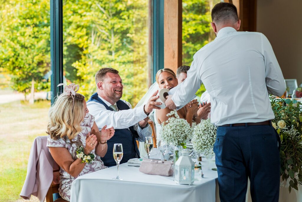 Wedding guests laughing and clapping at speech