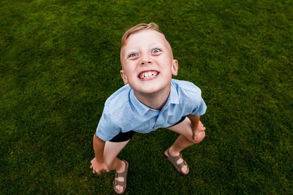 Boy smiling playfully on grass