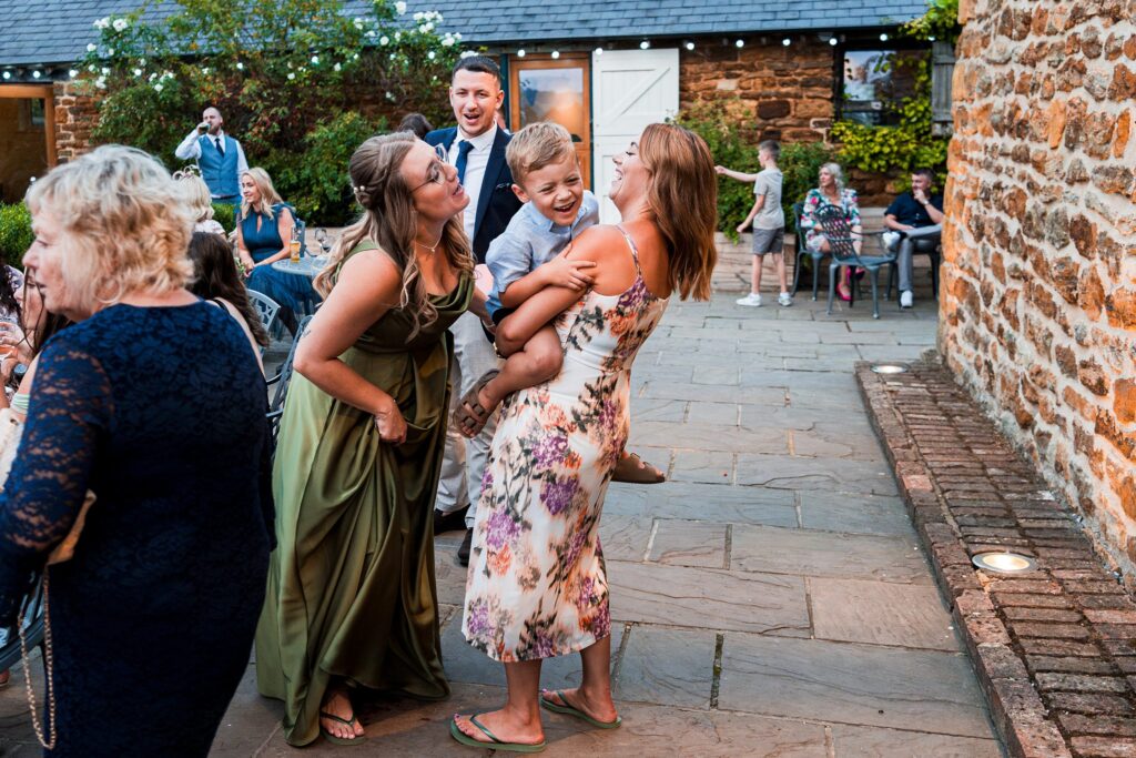 Guests laughing at outdoor wedding reception.