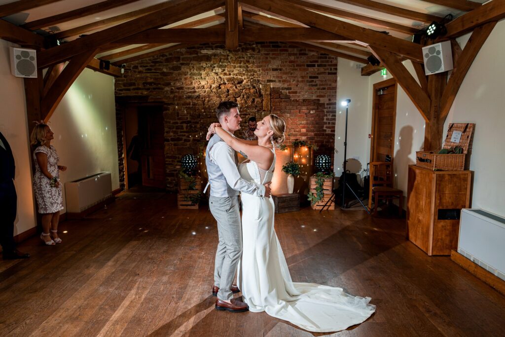 Couple dancing in rustic wedding venue.
