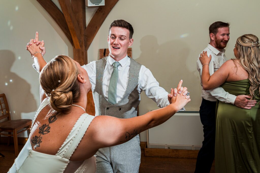 Couples dancing joyfully at a wedding reception.