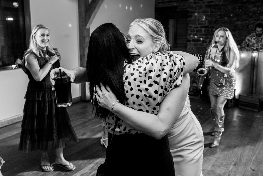 Women hugging at a lively celebration.