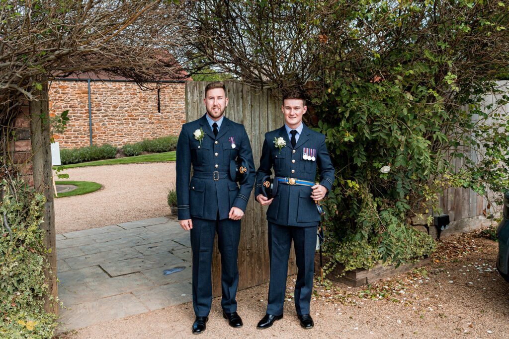 Two men in military uniforms smiling outdoors.