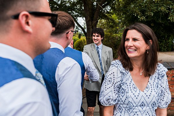 People smiling at outdoor gathering in summer clothing.