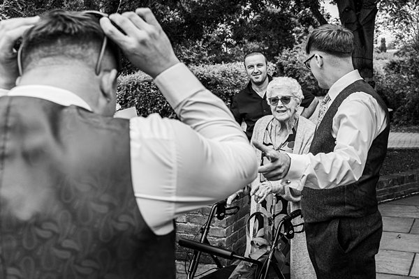 Group of people chatting outdoors, one holding sunglasses.