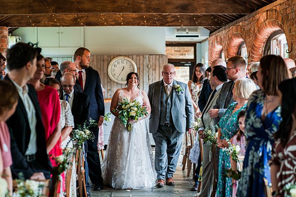 Bride and father walking down aisle at wedding