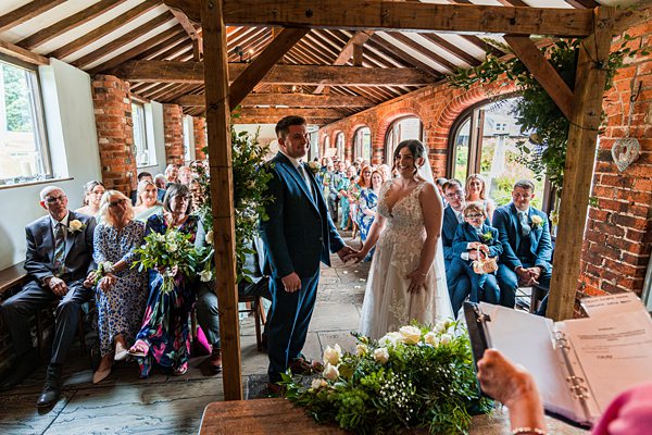 Bride and groom holding hands during wedding ceremony.