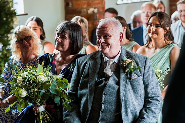 Guests smiling at a wedding ceremony.