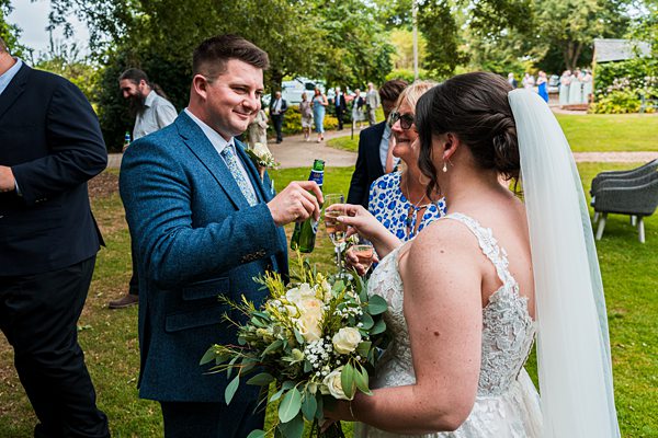 Wedding toast with bride and groom outdoors.
