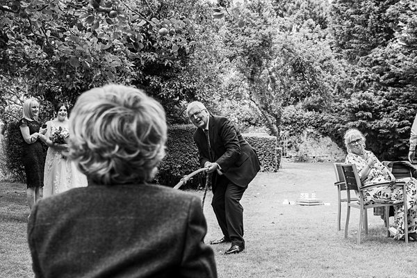 Man tugging rope at garden event with onlookers.
