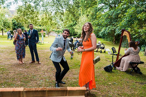 Guests dancing outdoors, harpist playing nearby