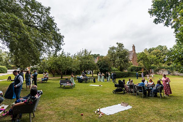 Outdoor gathering in a garden with people socialising.