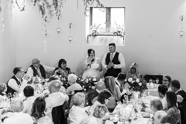 Bride giving wedding speech at reception dinner.