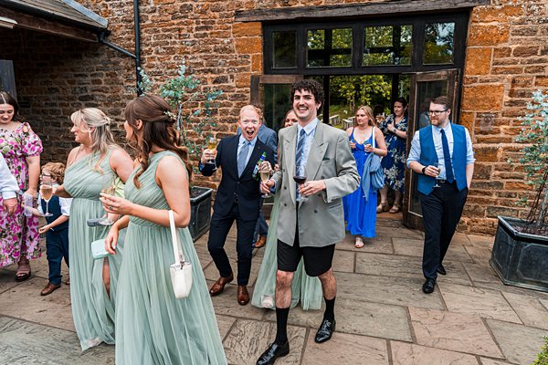 Guests enjoying drinks at outdoor wedding reception.