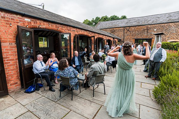 Outdoor wedding reception with guests enjoying conversation.