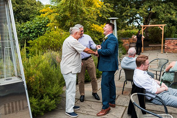 Group of men talking at outdoor event.