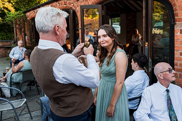 Man taking photo of woman at outdoor gathering