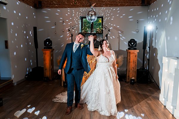 Wedding couple dancing under disco ball lights.