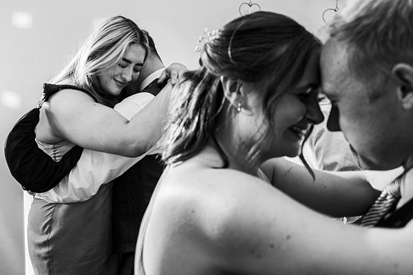 Couples dancing closely at a wedding reception.