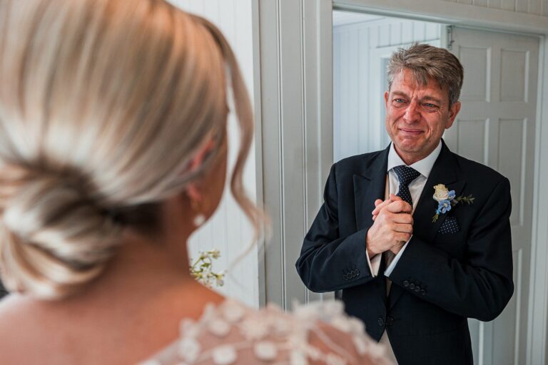 Tearful father sees bride before wedding ceremony.