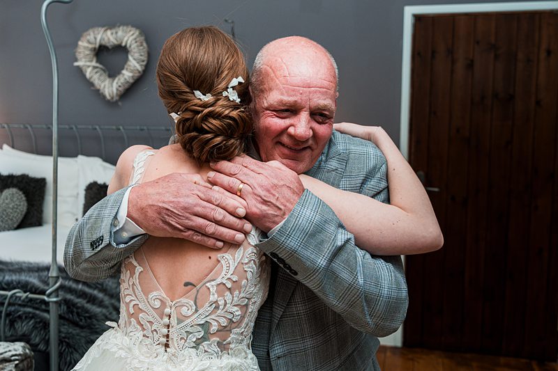 Bride hugging elder in wedding attire.