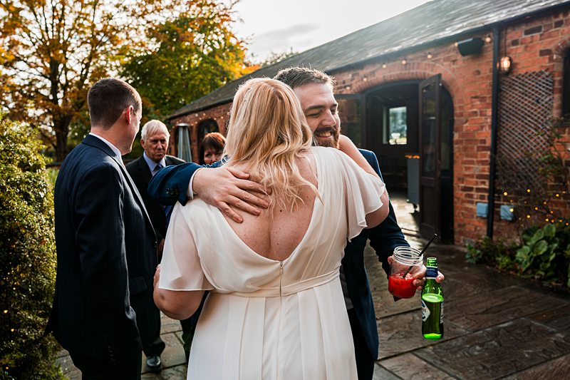 Guests hugging at outdoor autumn wedding reception
