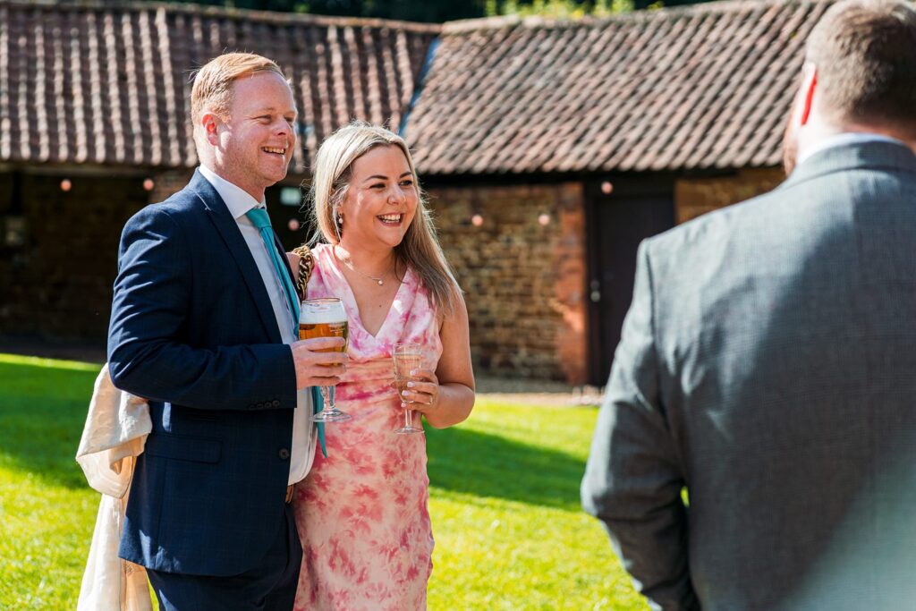Smiling couple holding drinks at outdoor event