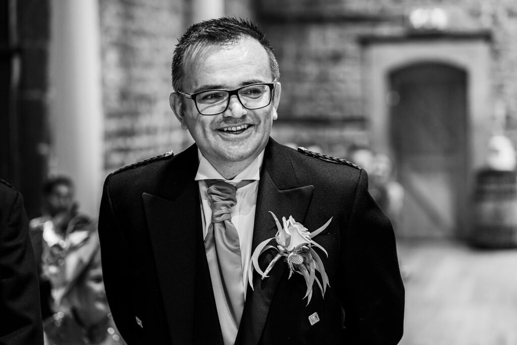 Man smiling in formal attire at an event.