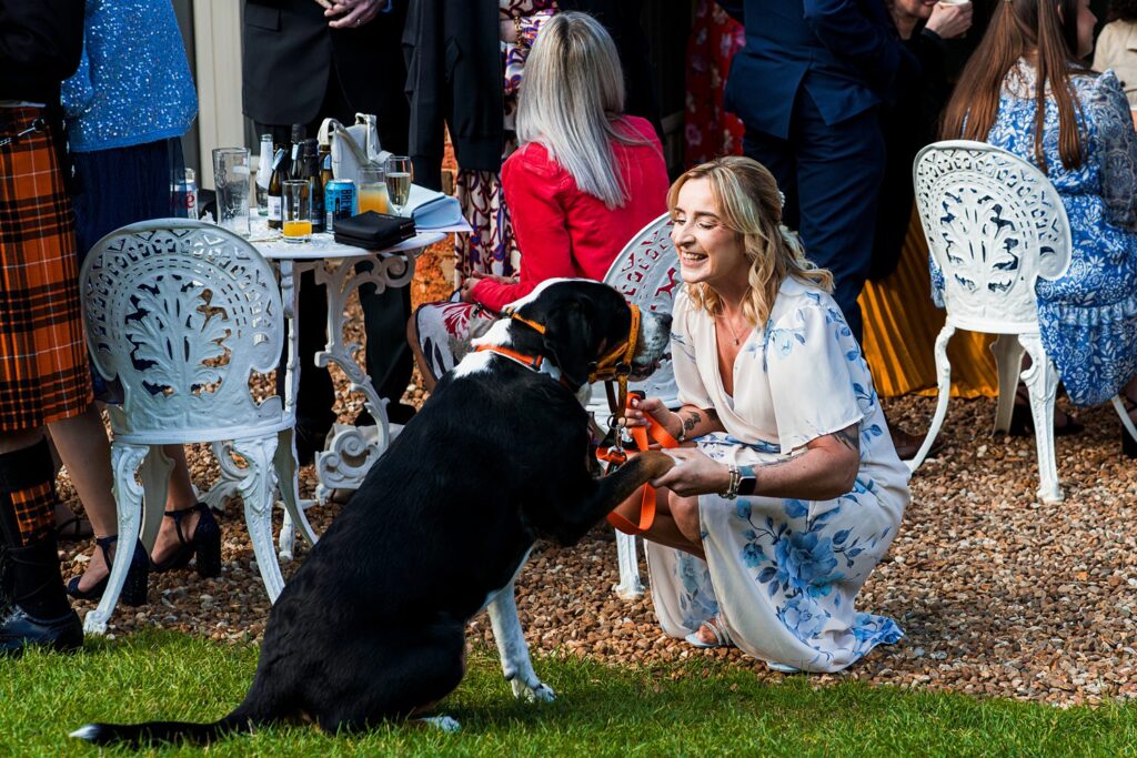 Woman smiling with dog at outdoor event.