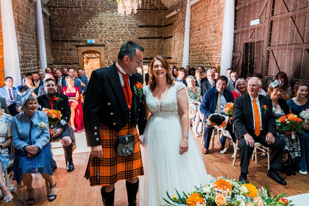 Bride and groom smiling during wedding ceremony.