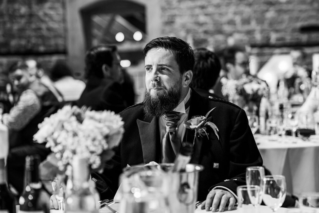 Bearded man in formal attire at a banquet.