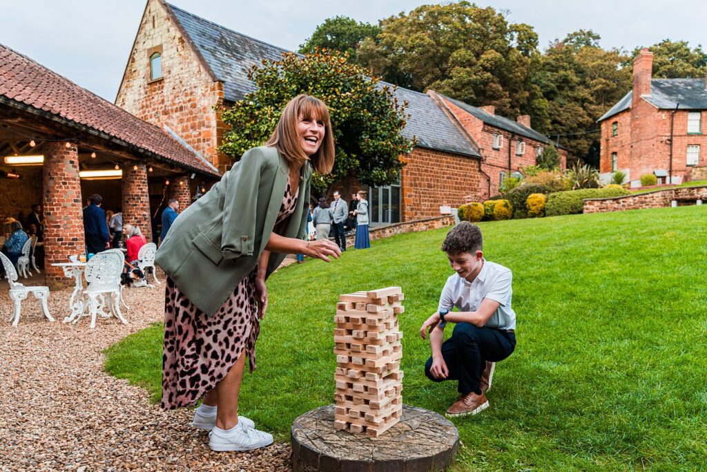 People playing Jenga in a garden setting.