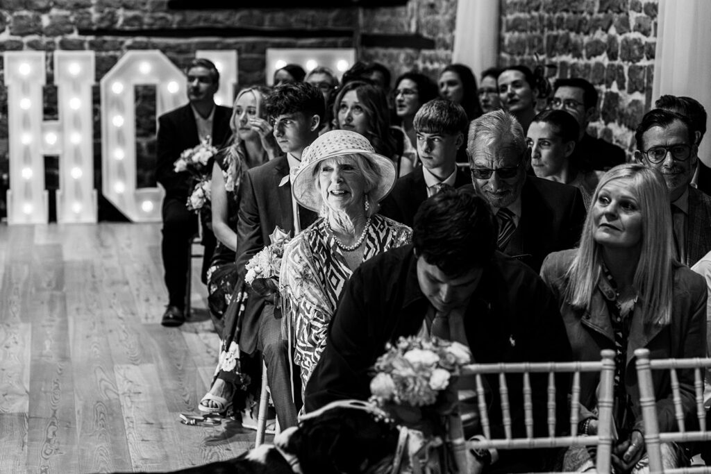 Guests seated at an indoor wedding ceremony.