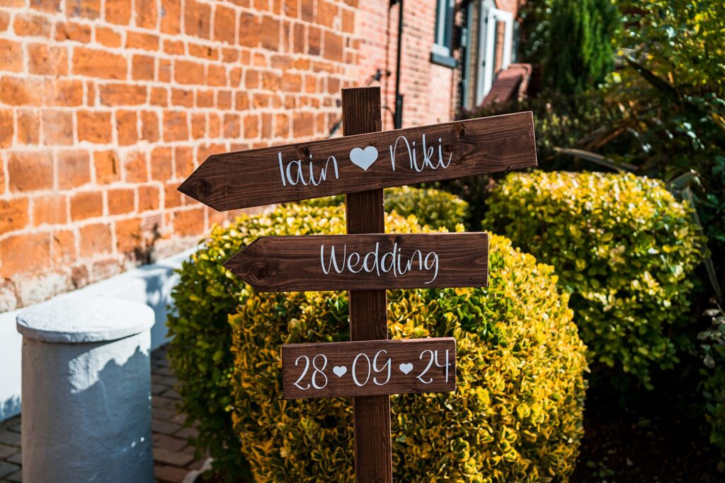 Wooden wedding sign with names and date.