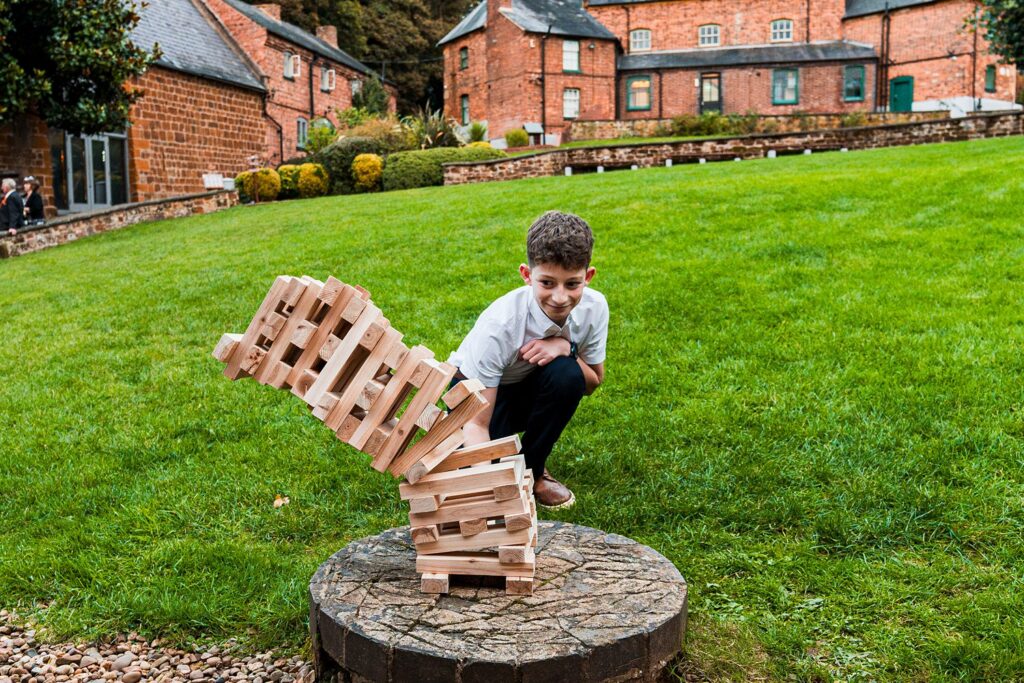 Child playing with wooden blocks outdoors.