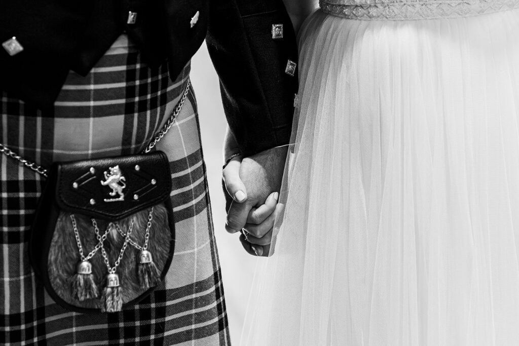 Bride and groom holding hands in wedding attire.