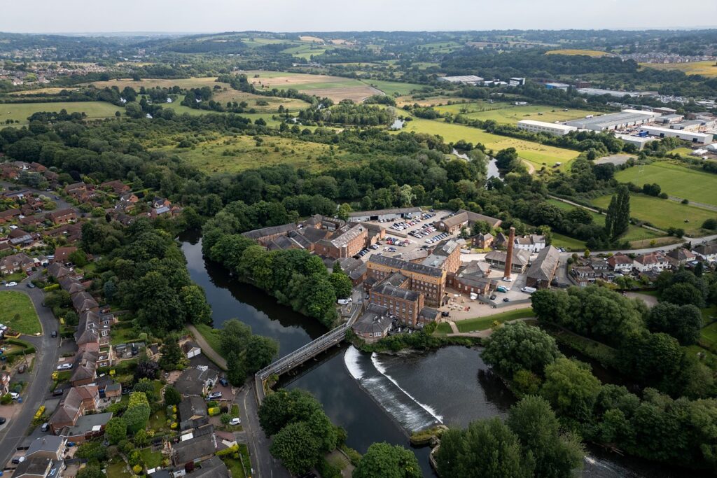 Aerial view of a historic mill in countryside landscape.
