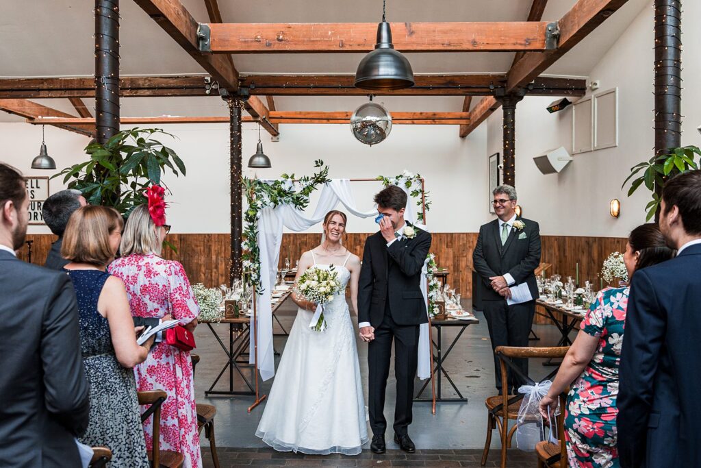 Bride and groom at indoor wedding ceremony.