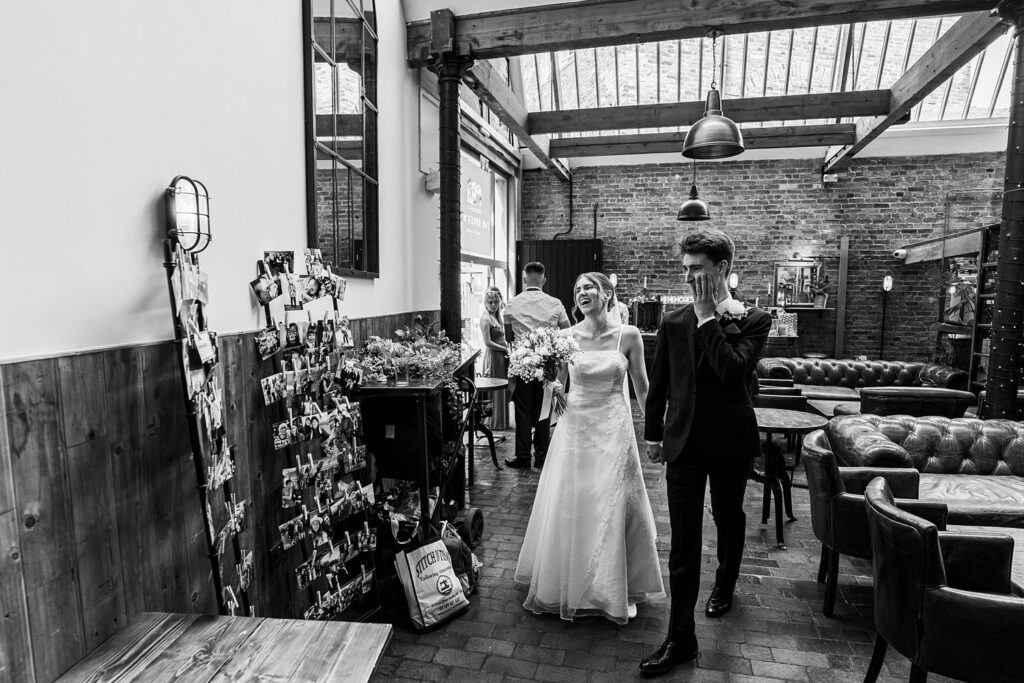 Bride and groom smiling in rustic venue.
