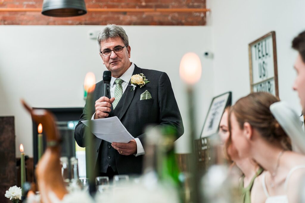 Man giving speech at wedding reception.