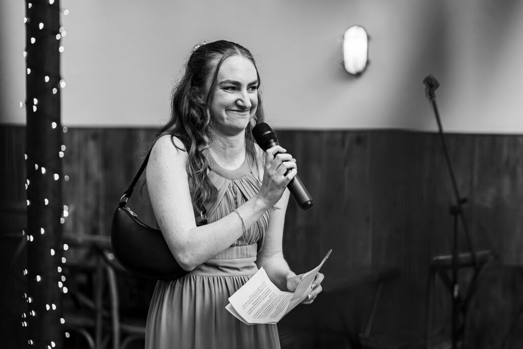 Woman speaking into microphone during event.