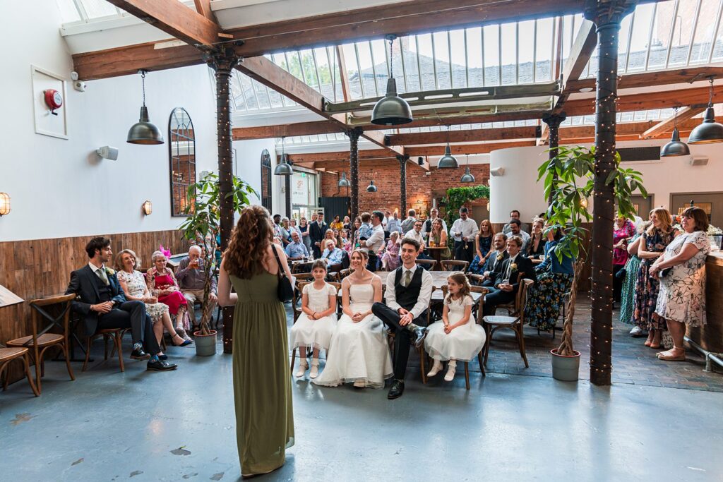 Wedding ceremony with guests in a rustic venue.