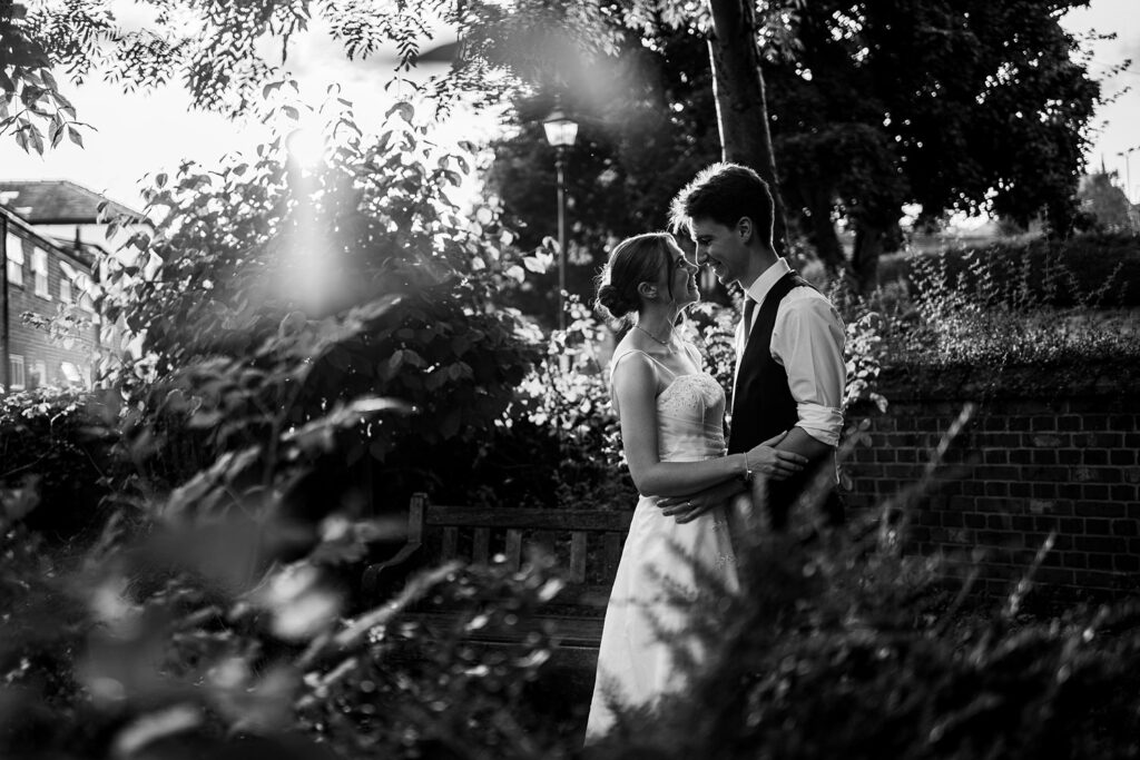 Couple embracing in garden during sunset.