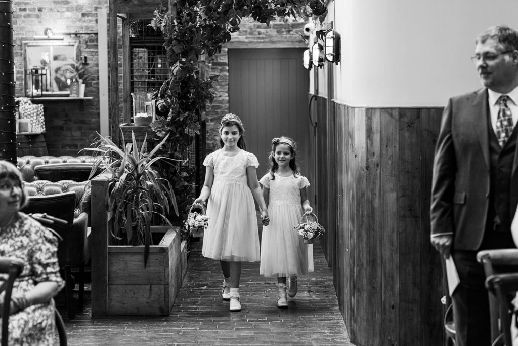 Two flower girls walking at wedding ceremony