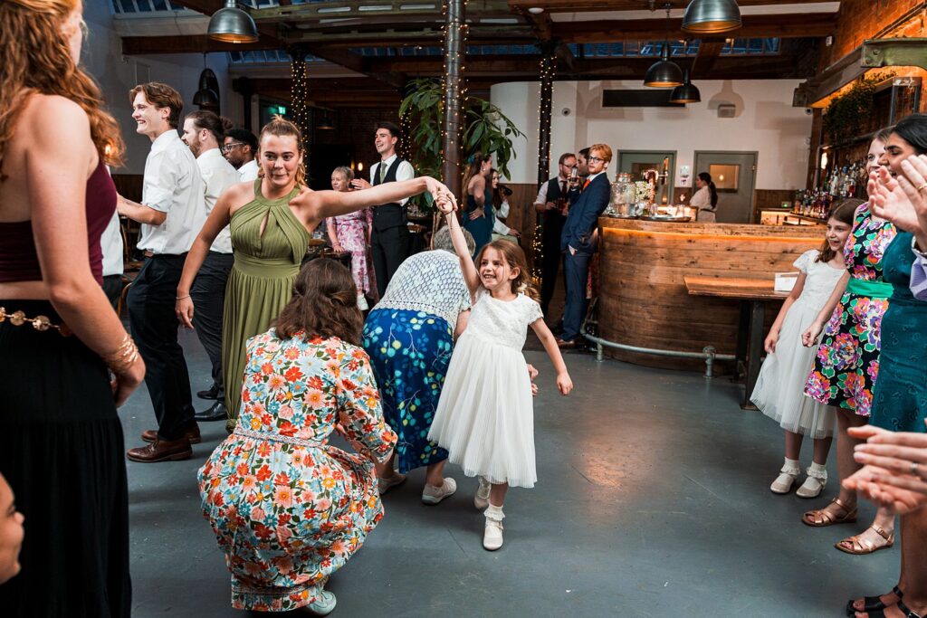 People dancing joyfully at a wedding reception.