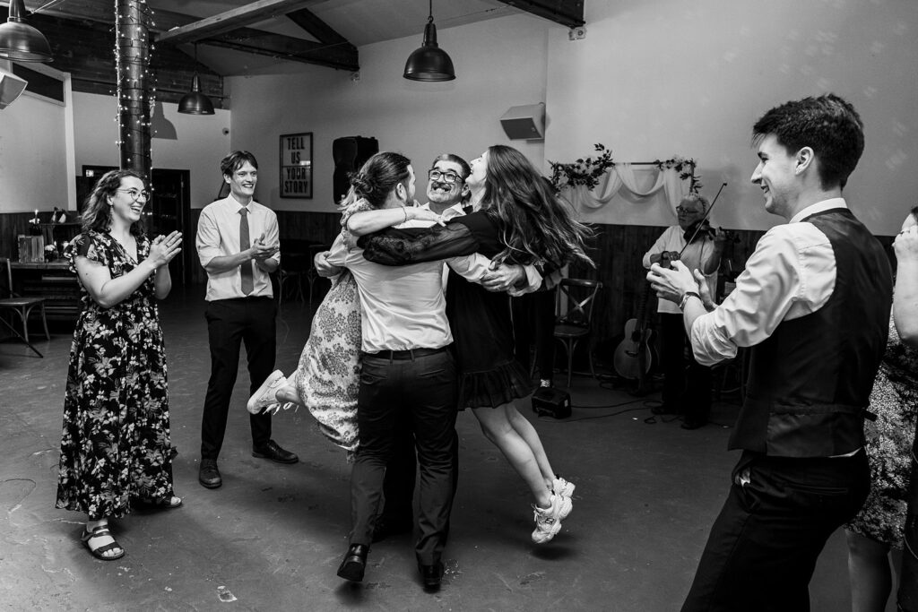 Group celebrating with joyful embrace and clapping.