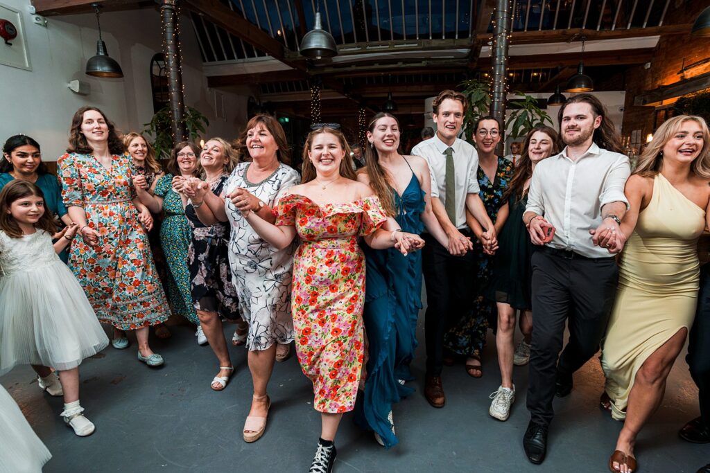 Happy group dancing at festive indoor event.