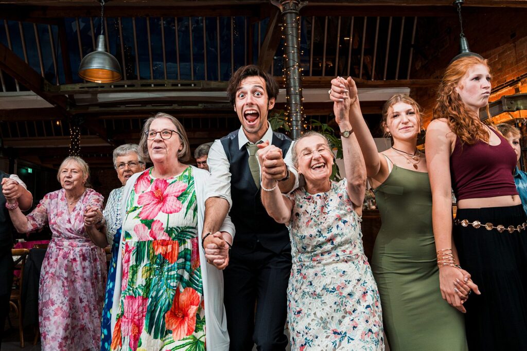 People holding hands in joy at a celebration.
